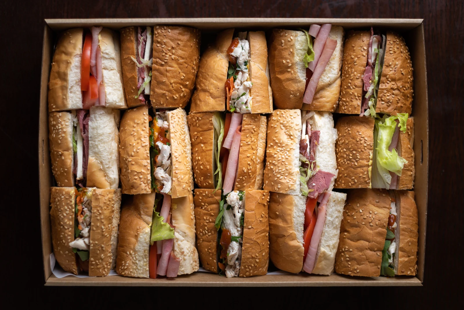 Assorted filled sandwiches neatly arranged in a catering tray